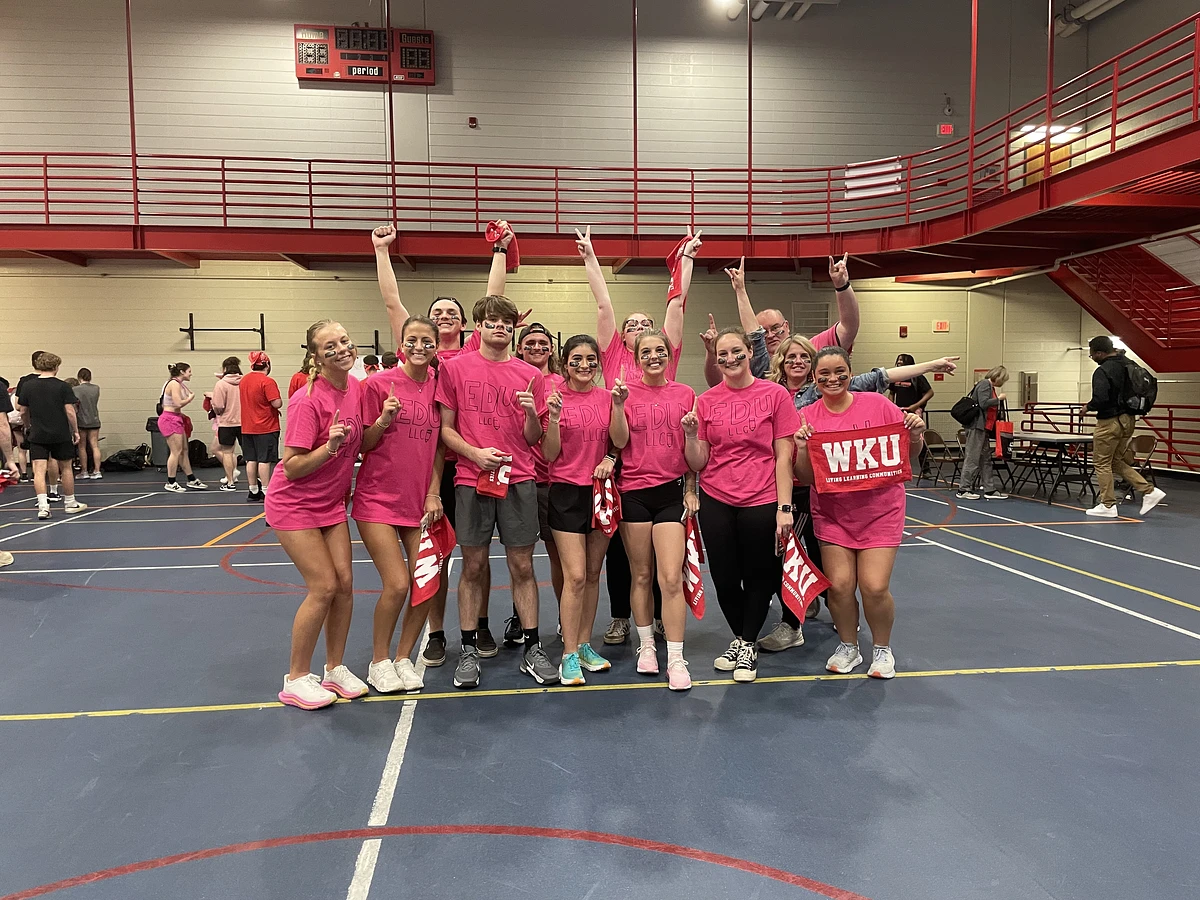 WKU students in pink shirts smile for a group photo at LLC Field Day