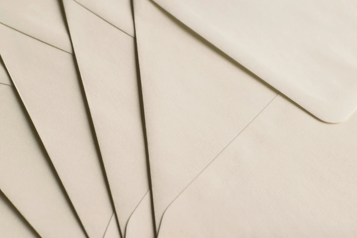 Several beige envelopes are arranged in a fan-like pattern.